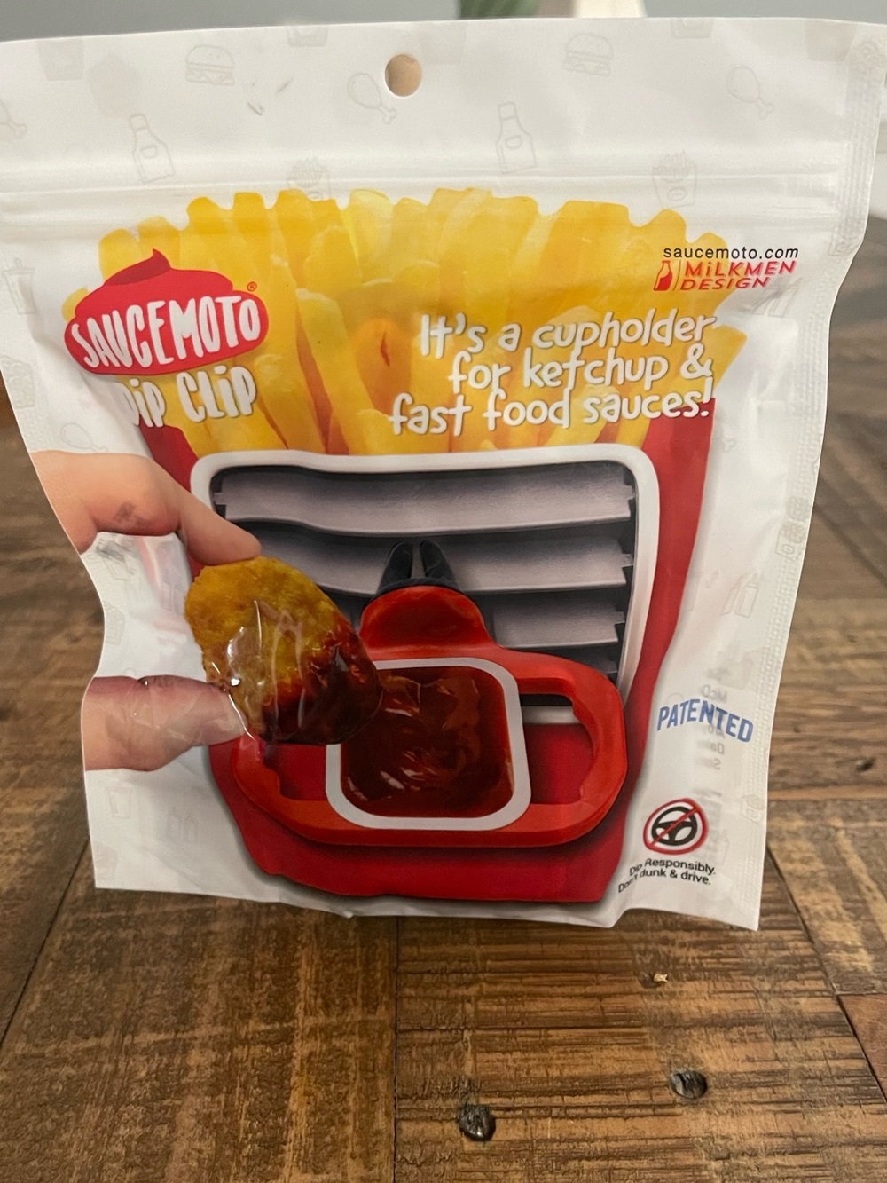 Saucemoto Dip Clip designed to hold fast-food sauce containers securely